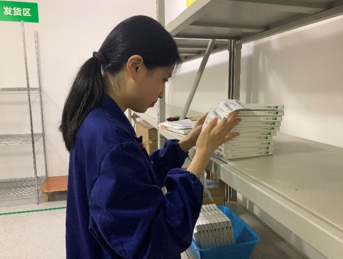 圖為金華市中心醫(yī)院工作人員將追溯二維碼粘貼到醫(yī)療器械包裝盒上。何璇 攝