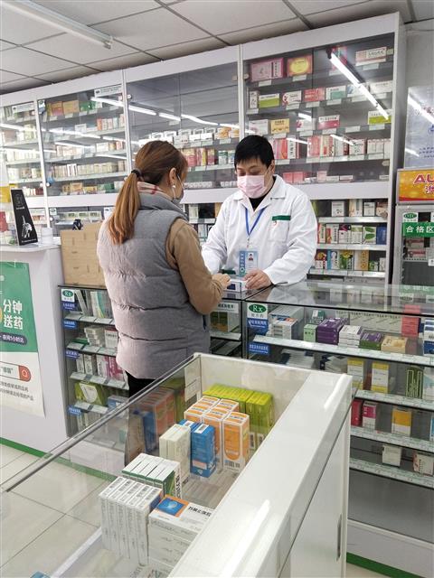 疫情防控時期，魏駿在藥店為顧客提供藥學(xué)服務(wù)。
