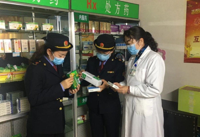 監(jiān)管人員正在藥品經營企業(yè)檢查該企業(yè)藥品儲存情況