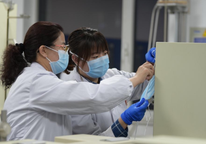 技術(shù)人員對口罩等疫情防控用品進(jìn)行檢驗(yàn)。