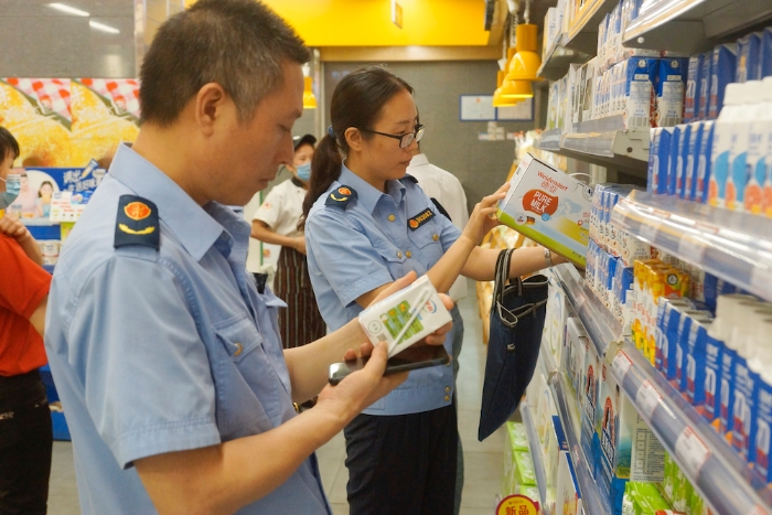 執(zhí)法人員在一家超市檢查乳制品質(zhì)量