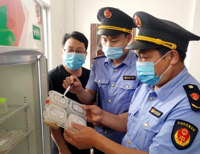 圖為6月8日該局執(zhí)法人員在一鄉(xiāng)鎮(zhèn)學校食堂檢查食品留樣。