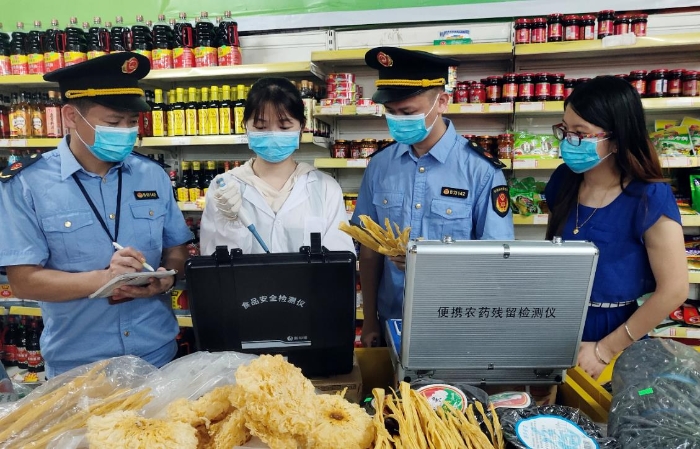 圖為6月21日該局執(zhí)法人員正在一超市檢測食品。