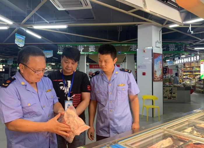 圖為該局執(zhí)法人員在一家農(nóng)貿(mào)市場(chǎng)冷凍食品專柜進(jìn)行檢查。