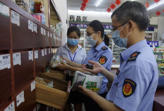 圖為執(zhí)法人員在一家零售藥店檢查中藥飲片。