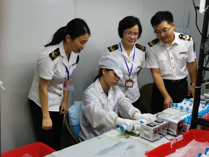 工作人員在檢查紅外體溫計、口罩生產(chǎn)企業(yè)。
