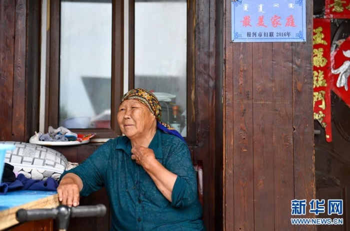 中妮浩坐在位于敖魯古雅鄂溫克族鄉(xiāng)的家門口休息（7月14日攝）。 新華社記者 貝赫 攝