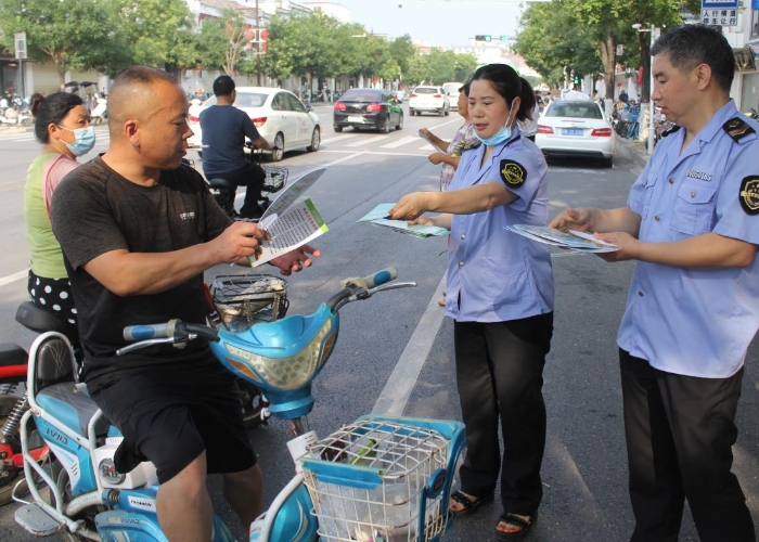 圖為該局執(zhí)法人員在縣城人民路向行人發(fā)放食品安全宣傳材料。