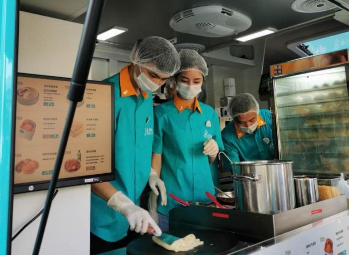 “逸小兔”流動(dòng)早餐車的店員正在為顧客備餐。新華網(wǎng)發(fā)（熊多多 攝）