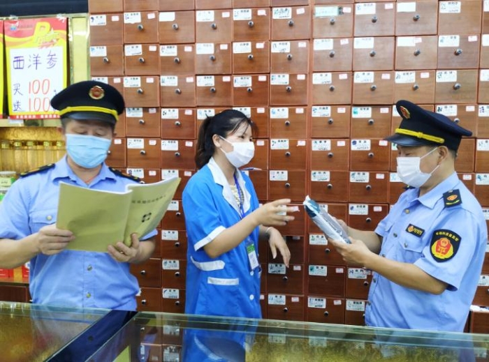 圖為執(zhí)法人員在一家零售藥店檢查中藥飲片進貨臺賬、質(zhì)量安全等情況。