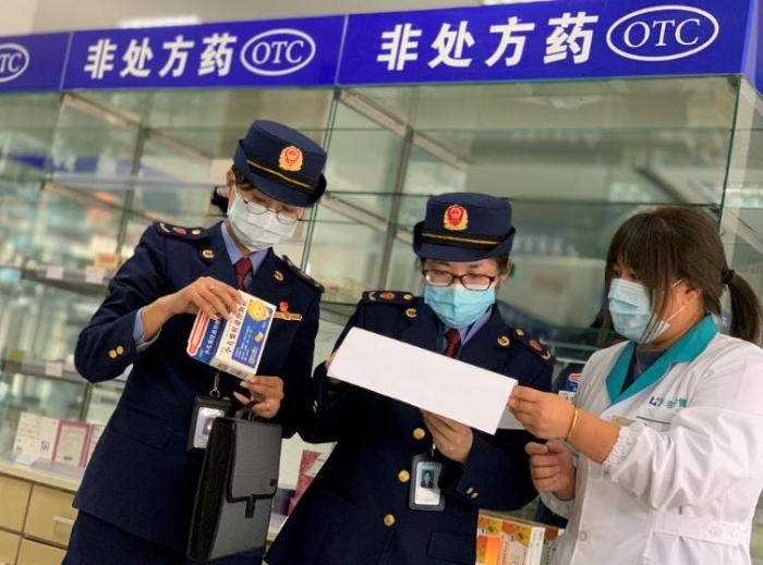 圖為該局執(zhí)法人員對發(fā)燒類藥品銷售登記進行檢查。