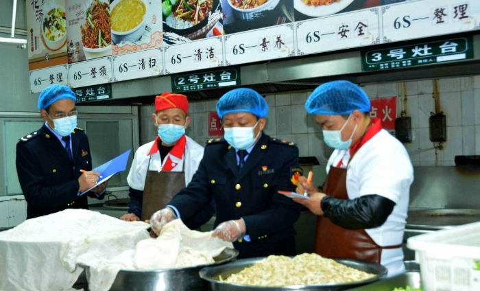 圖為4月7日，執(zhí)法人員在檢查某學(xué)校食堂操作間衛(wèi)生。