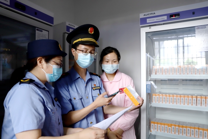 圖為5月21日該局執(zhí)法人員正在對市體育館內接種點的疫苗進行檢查。