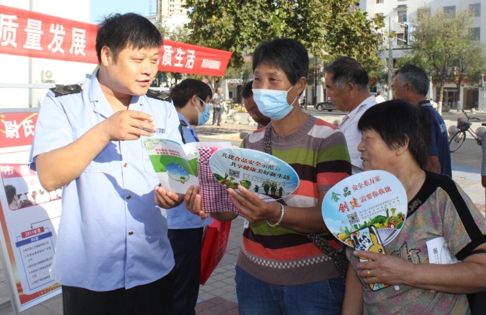 圖為執(zhí)法人員向群眾宣講食品安全知識(shí)。