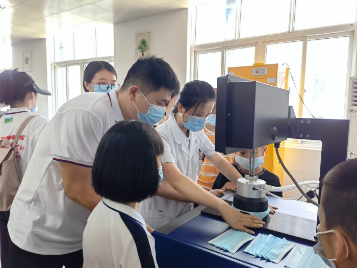 圖為技術(shù)人員在講解口罩的檢驗(yàn)方法和原理。（喻燦華 攝）