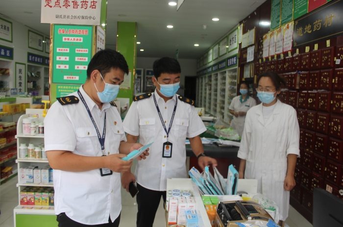 圖為執(zhí)法人員在一家藥店檢查口罩產品質量。