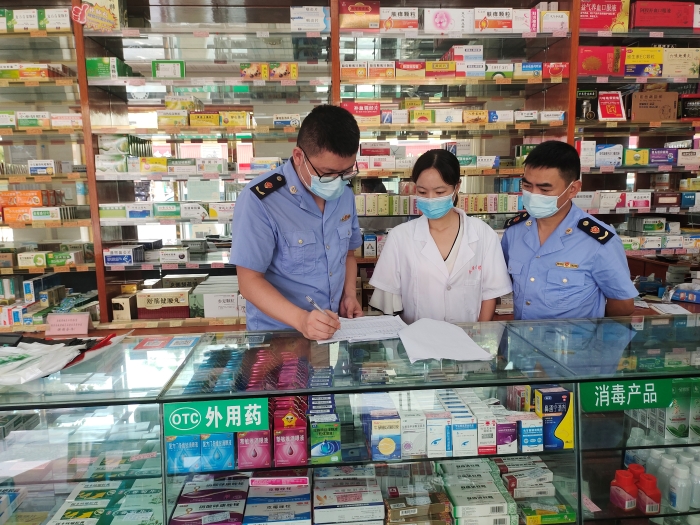 圖為監(jiān)管人員在一家藥店核對(duì)退燒、抗病毒等藥品銷售登記本。