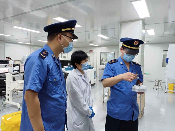 圖為執(zhí)法人員在一家醫(yī)療機構(gòu)檢查新冠病毒檢測試劑使用情況。