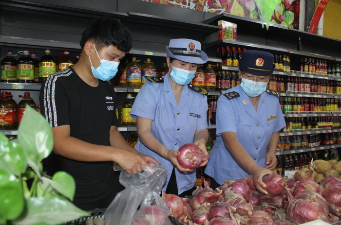 圖為執(zhí)法人員和檢測(cè)機(jī)構(gòu)工作人員抽取蔬菜樣品送檢。