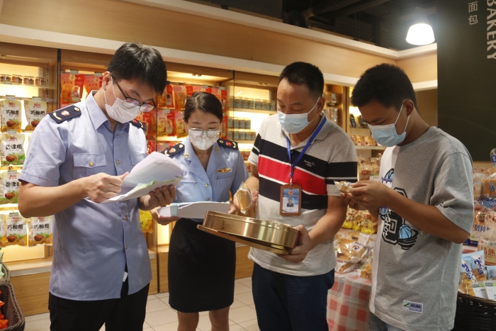圖為執(zhí)法人員查看月餅質(zhì)量情況。（柯潔 攝）