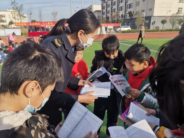 圖為工作人員為小學生講解安全用藥科普知識。