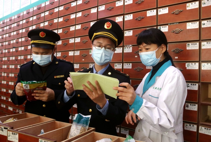 圖為11月24日執(zhí)法人員對一家藥店檢查中藥飲片。