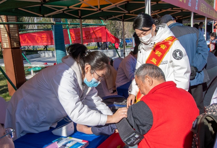 圖為醫(yī)護(hù)人員為群眾免費測量血壓并提供了健康用藥指導(dǎo)。