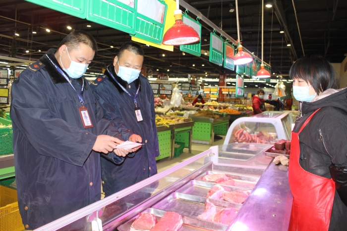 圖為執(zhí)法人員在一家商場檢查肉品相關手續(xù)。