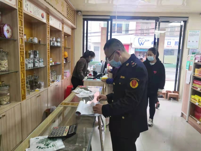 圖為執(zhí)法人員在一家藥店查看登記臺(tái)賬。