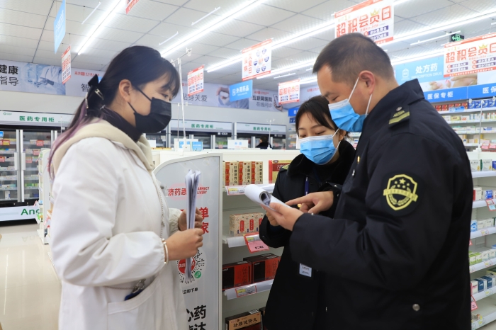 圖為1月11日?qǐng)?zhí)法人員在一家藥店檢查疫情防控情況。