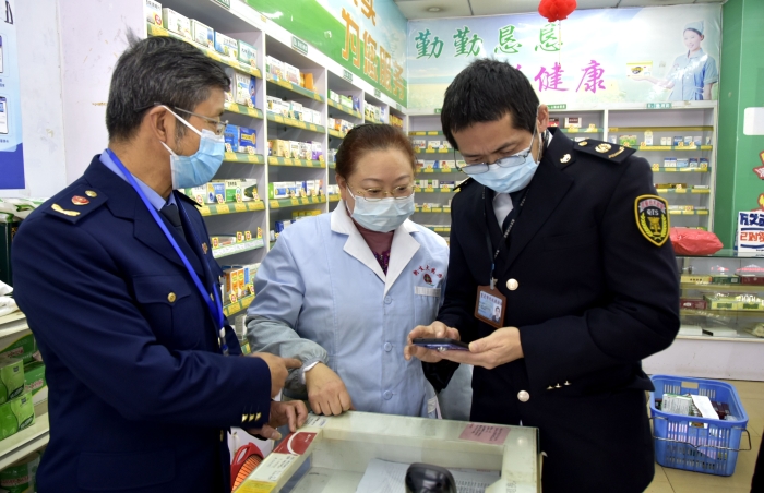 圖為執(zhí)法人員在一家藥店檢查藥品經(jīng)營(yíng)者的智慧監(jiān)管系統(tǒng)的使用情況。