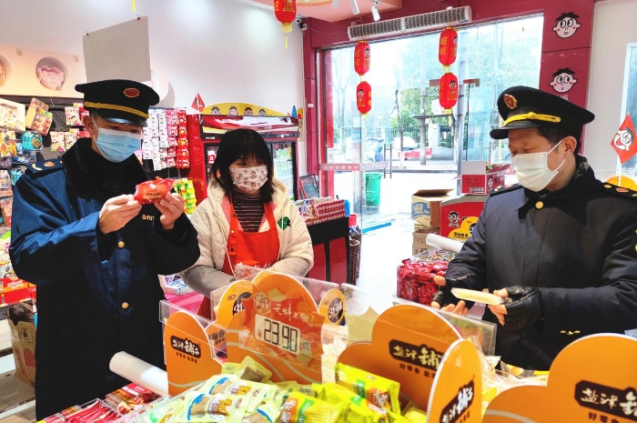 圖為執(zhí)法人員在學(xué)校周邊超市檢查兒童食品質(zhì)量。