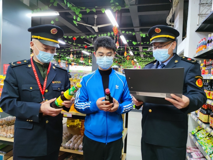 圖為執(zhí)法人員在一家超市檢查調(diào)味品質(zhì)量。