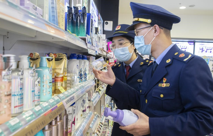 圖為執(zhí)法人員在超市化妝品專柜檢查化妝品標(biāo)簽標(biāo)識(shí)情形。