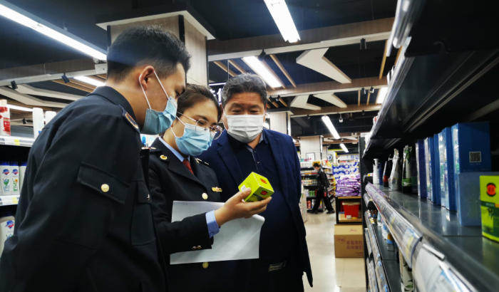圖為執(zhí)法人員在化妝品銷售現(xiàn)場進行檢查。