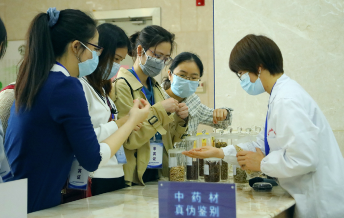 圖為工作人員為市民代表講解中藥材鑒別知識。
