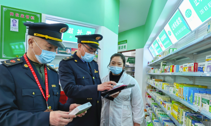 圖為執(zhí)法人員檢查“四類藥品”銷售登記情況。