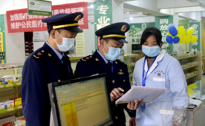 圖為執(zhí)法人員在一家藥店檢查疫情防控藥械銷售記錄。
