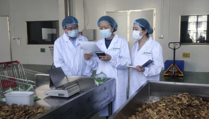 圖為執(zhí)法人員對防疫用中藥飲片質(zhì)量進行監(jiān)督檢查。
