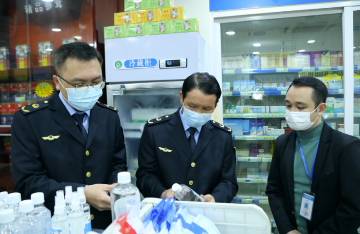 圖為執(zhí)法人員檢查口罩、酒精等防疫物資。
