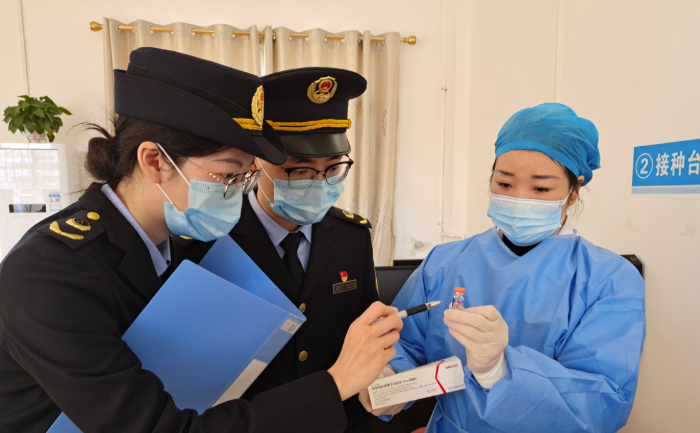 圖為執(zhí)法人員在一家醫(yī)院檢查新冠疫苗和抗原檢測試劑。