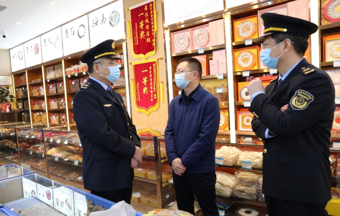 秦繼紅（左一）在中藥材市場聽取長沙市、雨花區(qū)市場監(jiān)管局負(fù)責(zé)人介紹相關(guān)情況。（喻燦華 攝）