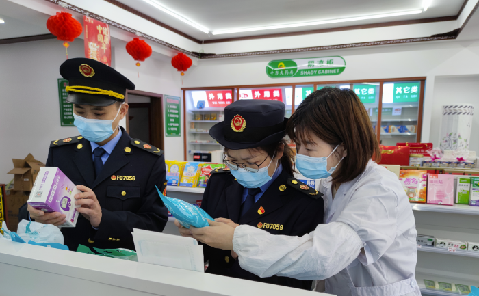 圖為執(zhí)法人員在藥店檢查疫情防控用品質(zhì)量。