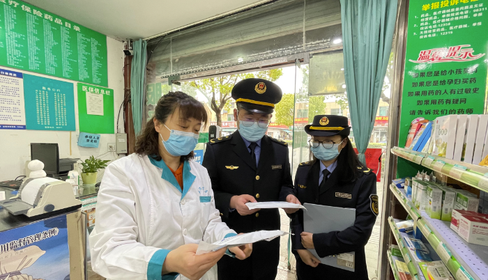 圖為執(zhí)法人員在一家藥店檢查疫情防控情況。