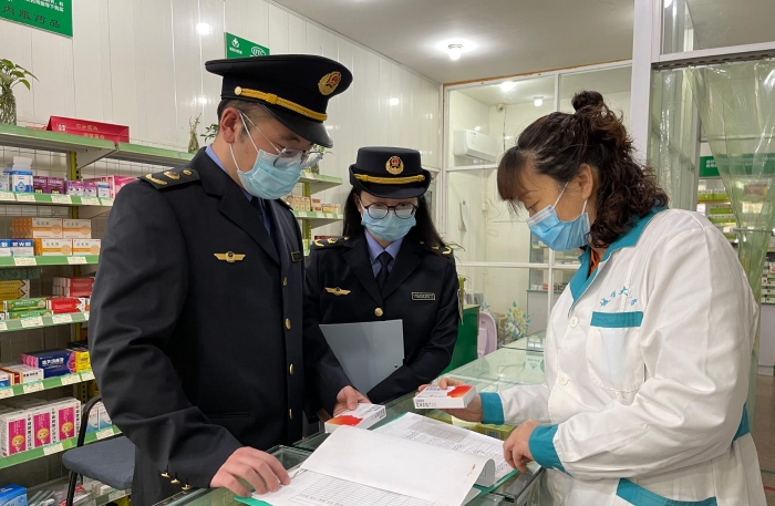 圖為執(zhí)法人員正在一家藥店檢查藥品信息登記情況。