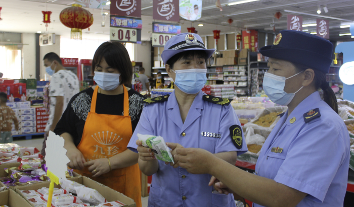 圖為執(zhí)法人員在一家商場食品專柜進行執(zhí)法檢查。