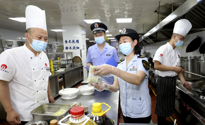 圖為淮北市市場監(jiān)管局執(zhí)法人員在一家學(xué)校食堂檢查食品加工環(huán)境。