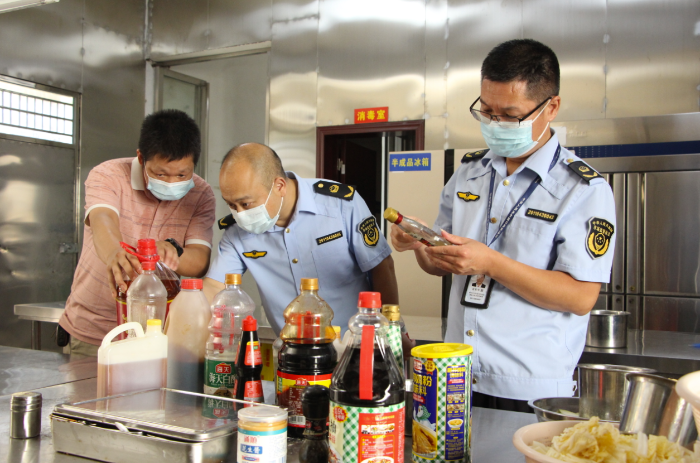圖為該局執(zhí)法人員在一家餐飲服務(wù)單位檢查調(diào)味料的保質(zhì)期。