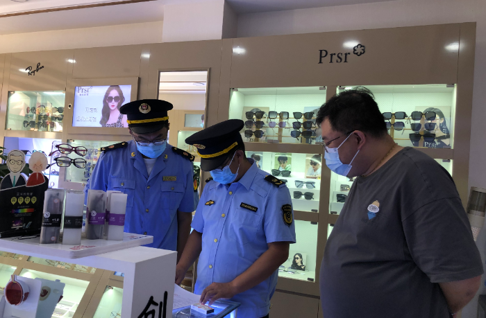 圖為第四分局執(zhí)法人員在一家眼鏡店查看進貨查驗記錄和銷售記錄。