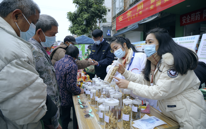 圖為工作人員現(xiàn)場向群眾講解常用中藥材的鑒別知識，普及藥品安全相關(guān)法律法規(guī)。